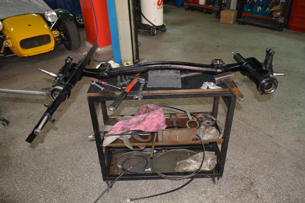 The front axle has been reconditioned; the special tooling is deployed to tighten the shock absorber caps of the sliding pillar suspension.